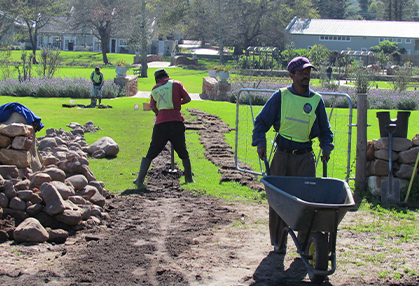 Team of workers preparing a garden for irrigation system